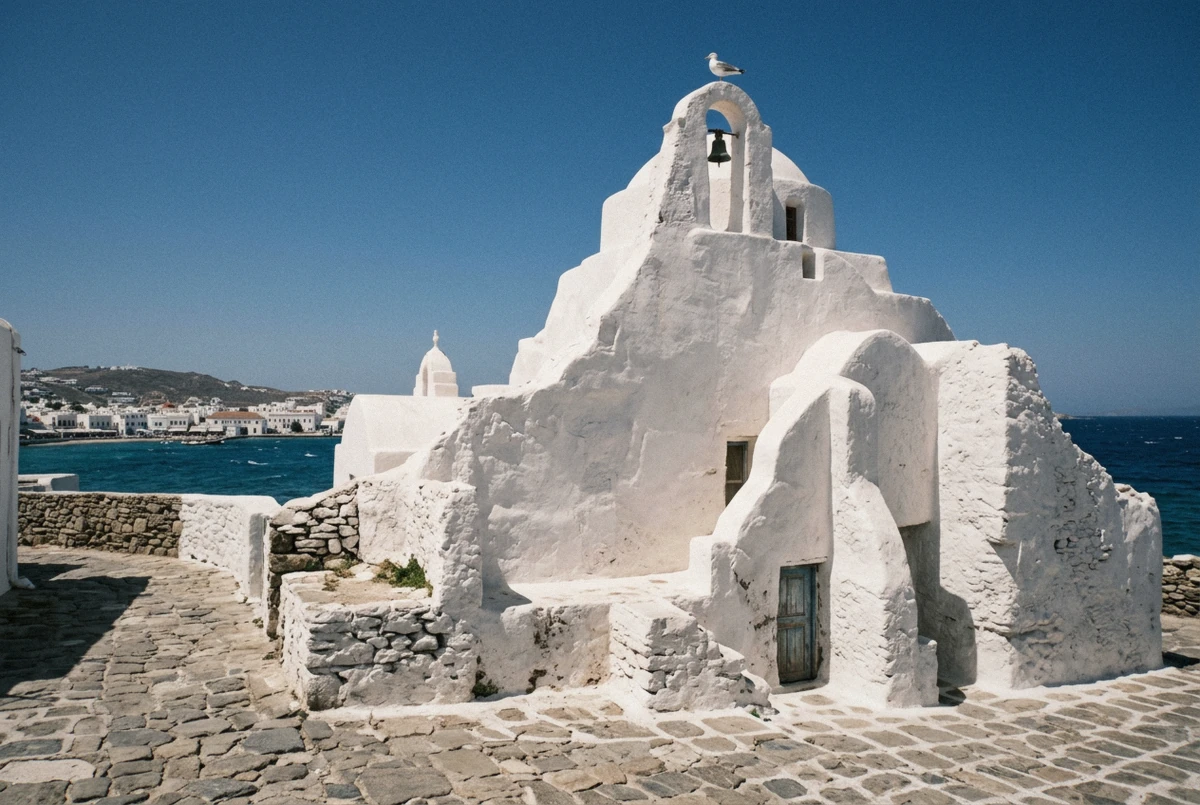 The sculpted whitewashed curves of Paraportiani church under blue sky, a classic Mykonos photoshoot backdrop